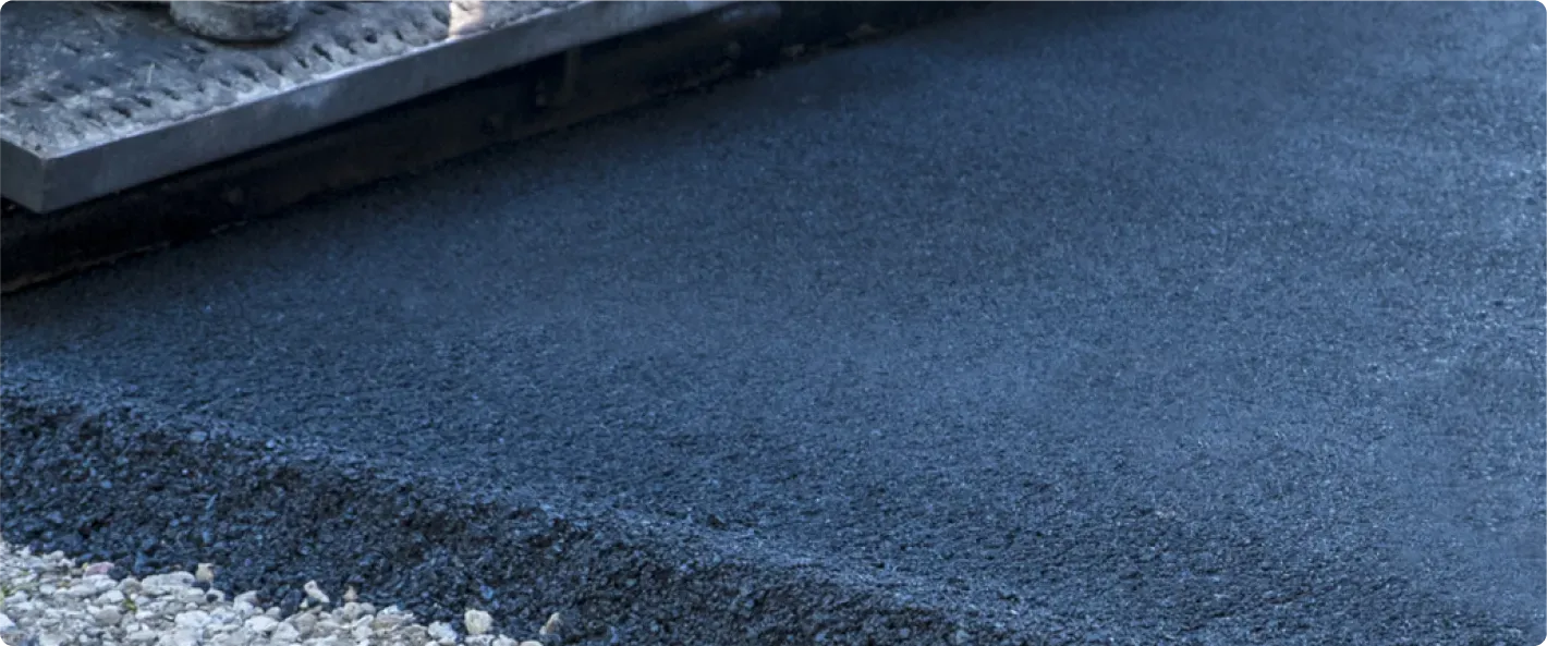 Laying fresh tarmac for a new driveway or paved surface.