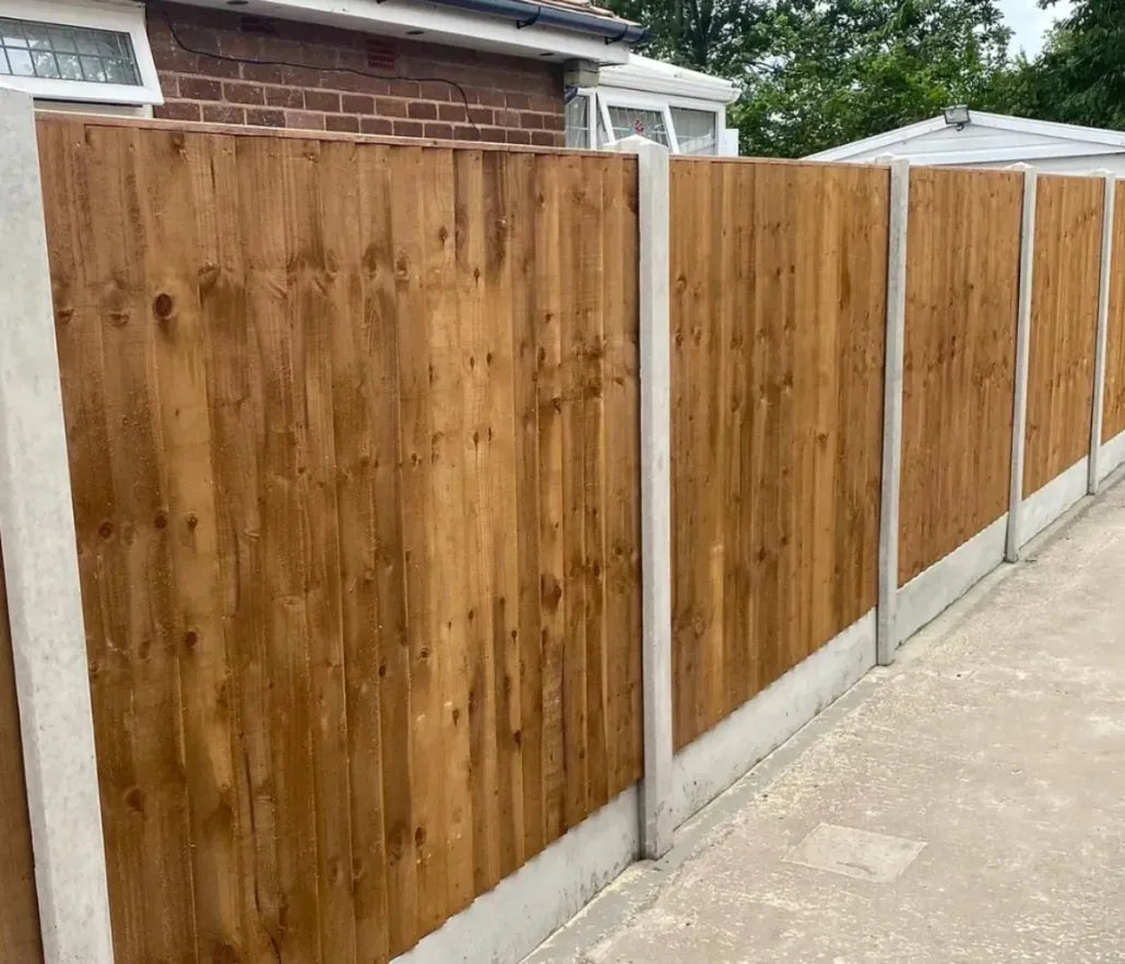 Newly installed wooden fence with concrete posts and gravel boards