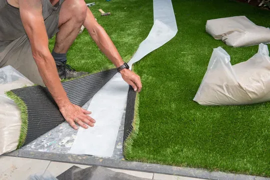 Expert laying artificial turf with joining tape
