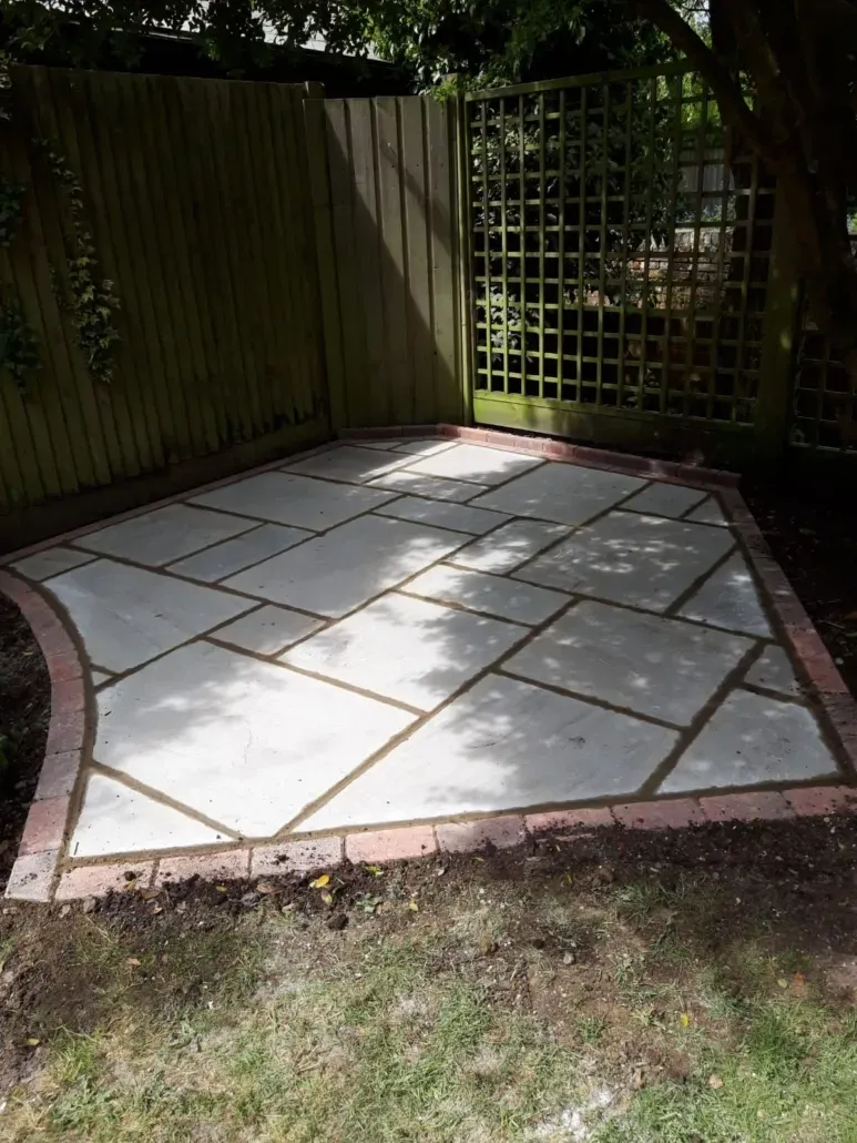 Recently completed garden patio with paving slabs and brick edging.
